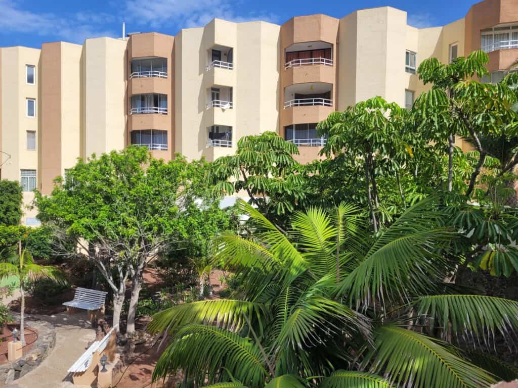 Moderne Apartmentanlage auf den Kanarischen Inseln, umgeben von tropischen Pflanzen und grünen Gärten, ideal für Urlaub und Immobilien auf den Kanaren.